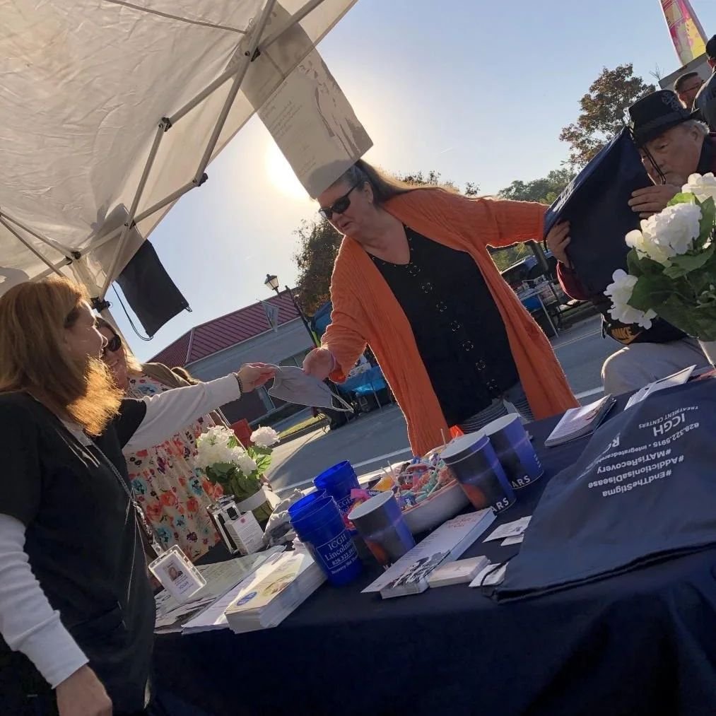 People talking at a community information table